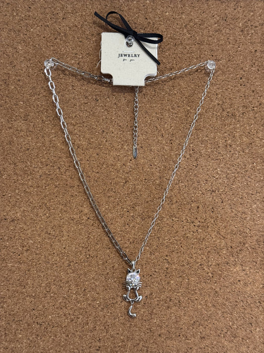 A silver-tone chain necklace featuring a small rhinestone-accented cat pendant.