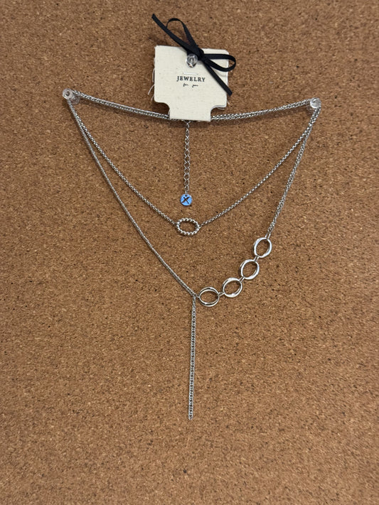 Silver-tone multi-layer necklace with interlocking circle links, a small blue bead charm and a dangling tassel chain.